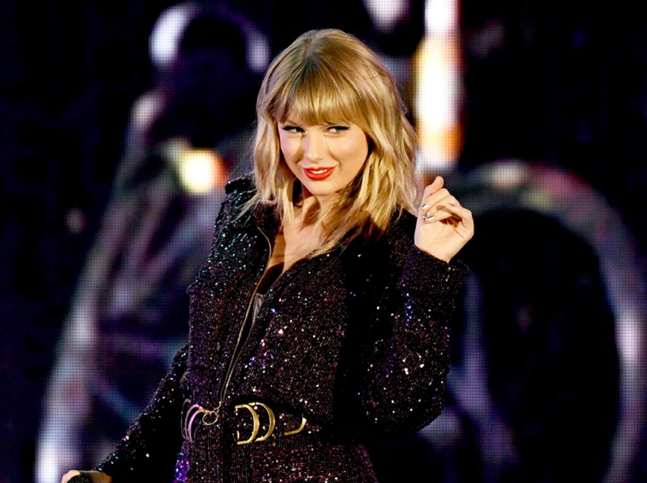 テイラー・スウィフト、ファンからの「贈り物」をブラジャーの中に押し込む