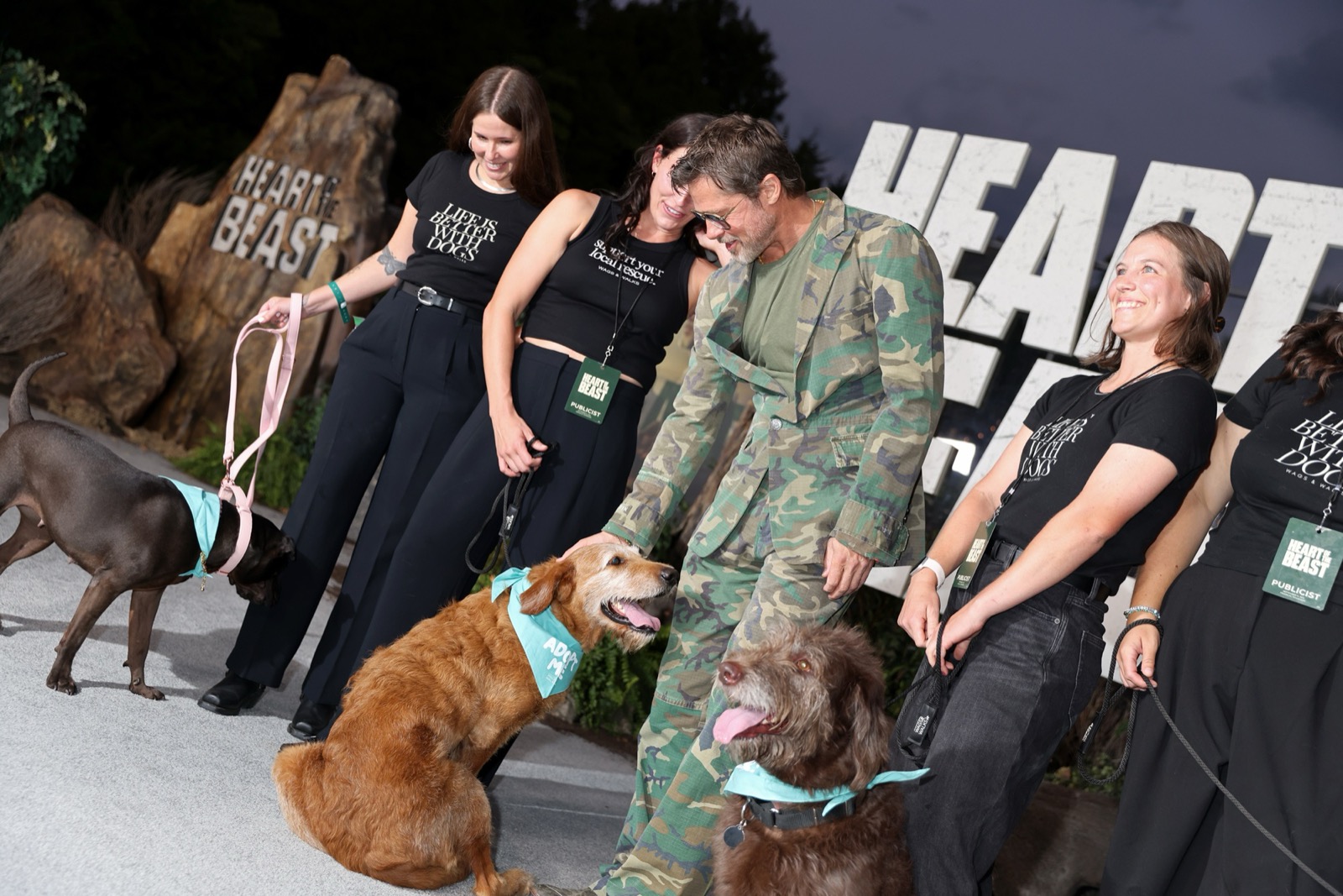 プレミアのカーペットで犬たちと触れ合うブラッド・ピット