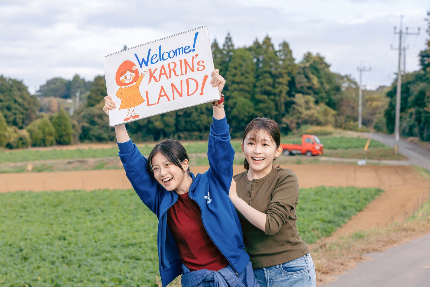 「KARIN'S LAND!」のボードを掲げる『メリーベリーラブ』の場面写真