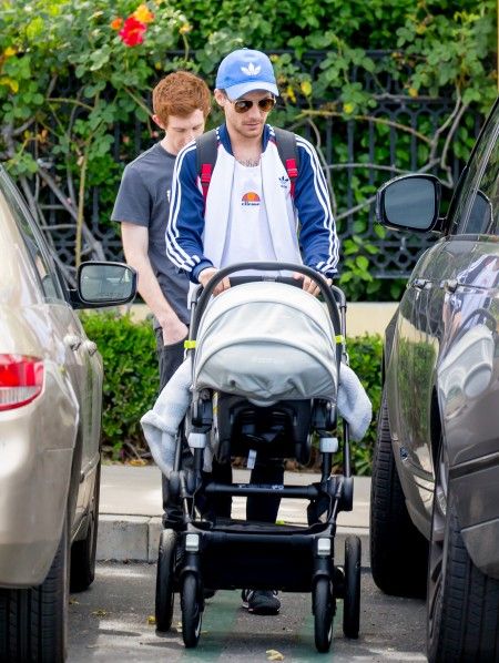 Louis Tomlinson smiles as he takes his son Freddie Reign for an afternoon stroll in Los Angeles, CA